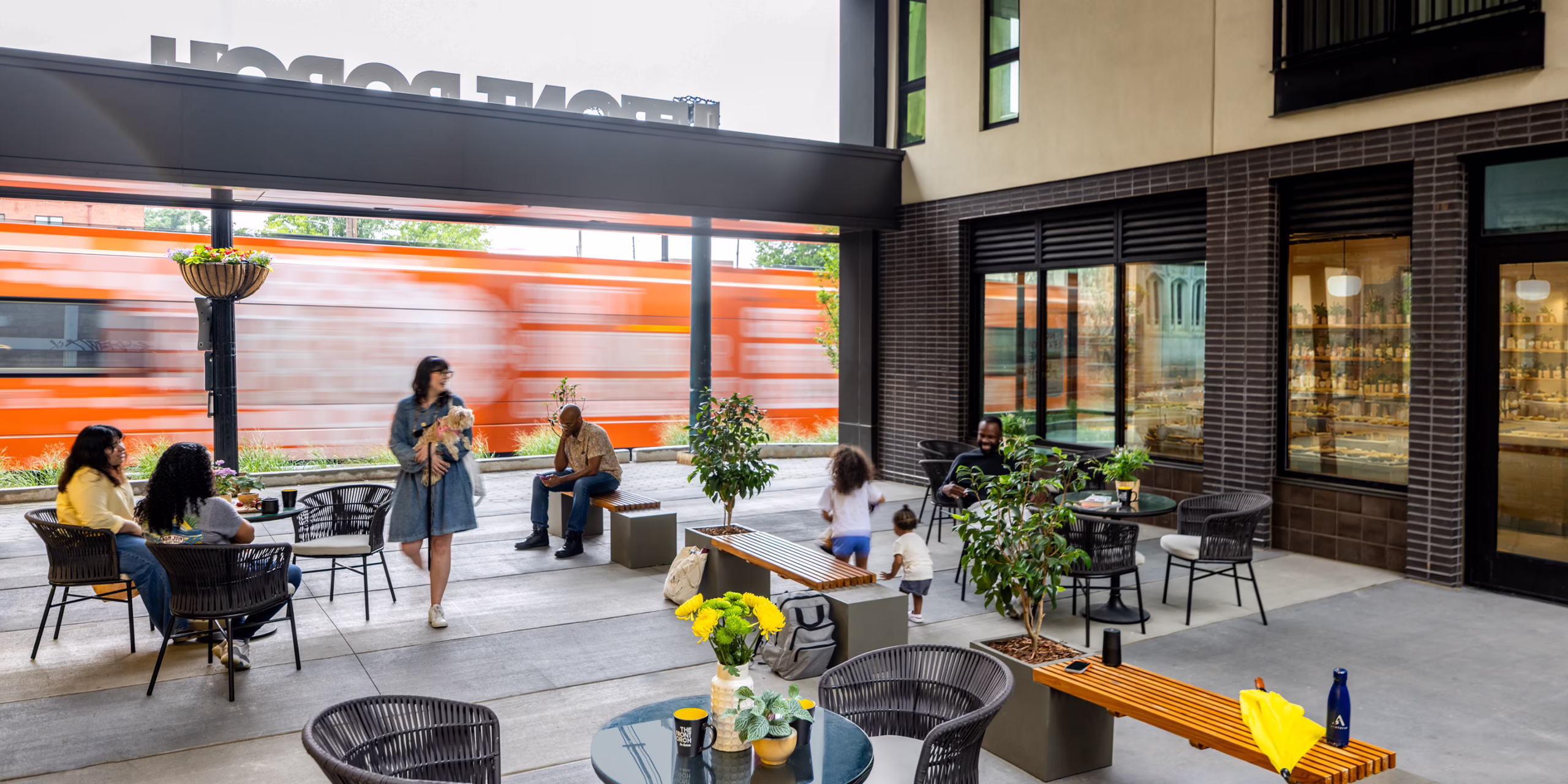 Front Porch Phase I courtyard with outdoor seating and MARTA train passing, Atlanta co-living community