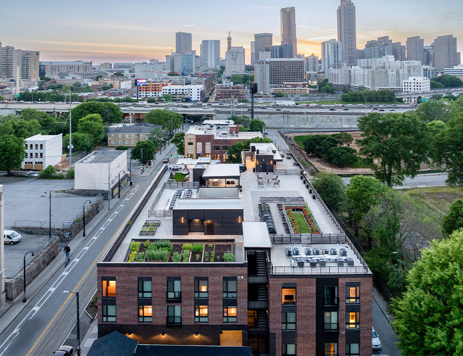 Aerial view of the Front Porch rooftop featuring community garden beds, a neighborhood farming program with raised planting rows, event and gathering spaces, and seating areas, with Auburn Avenue and surrounding Historic District neighborhood visible below.