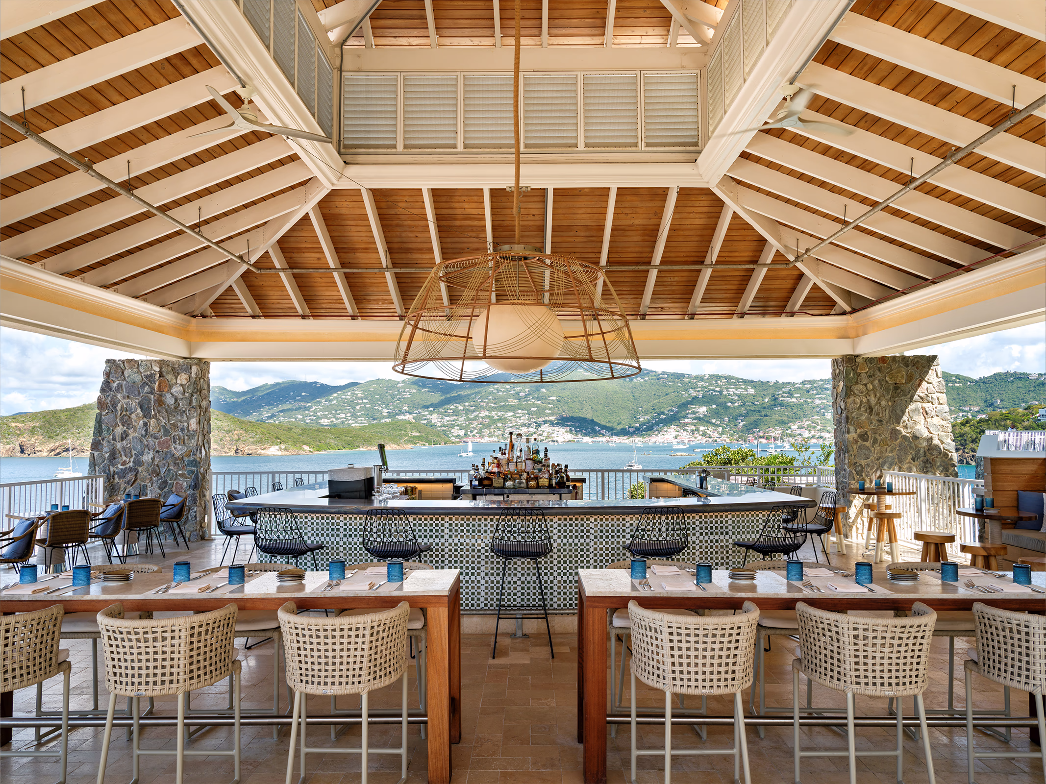 Oceanfront bar and dining terrace at Frenchman's Reef with checkerboard tile counter, wicker chairs, and sweeping harbor views.