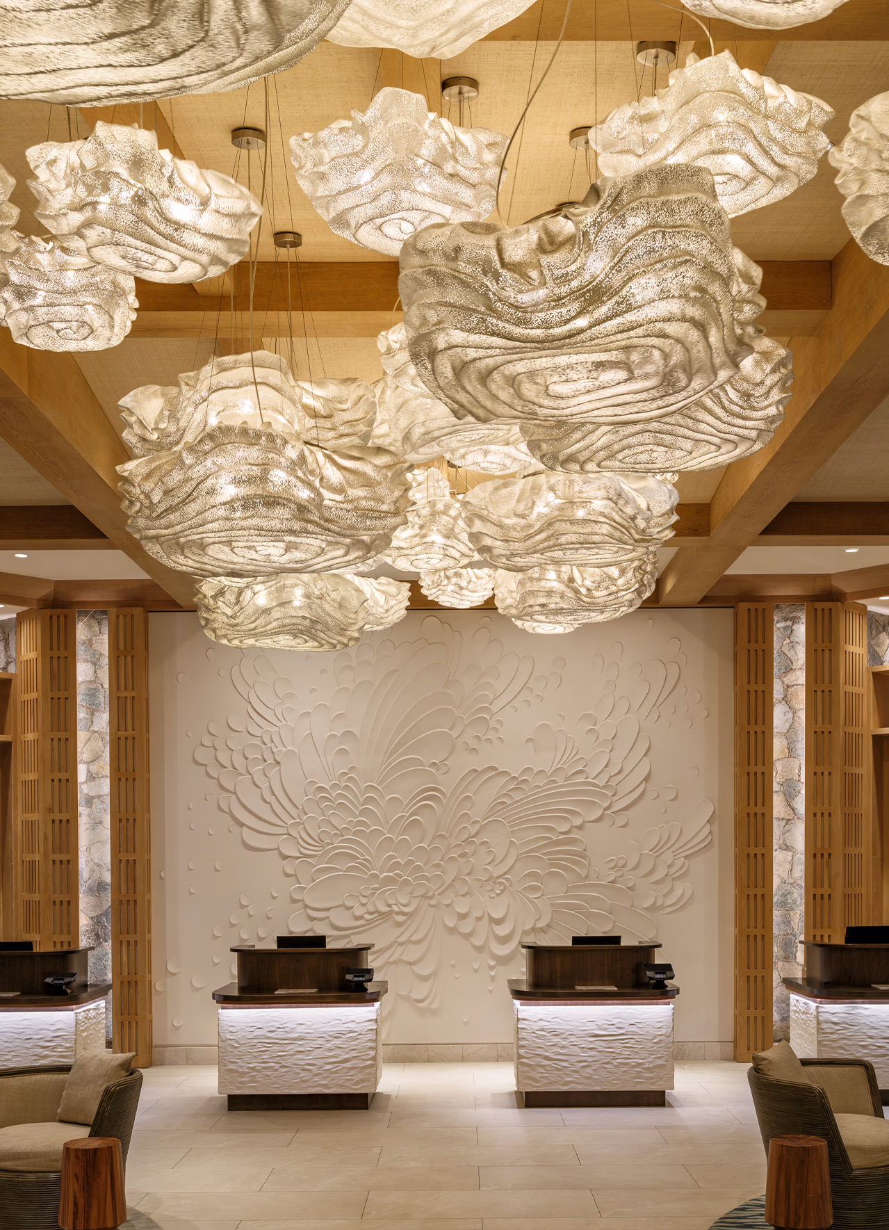Front desk at The Westin Frenchman's Reef beneath a carved chrysanthemum wall sculpture and cloud-shaped pendant lighting.