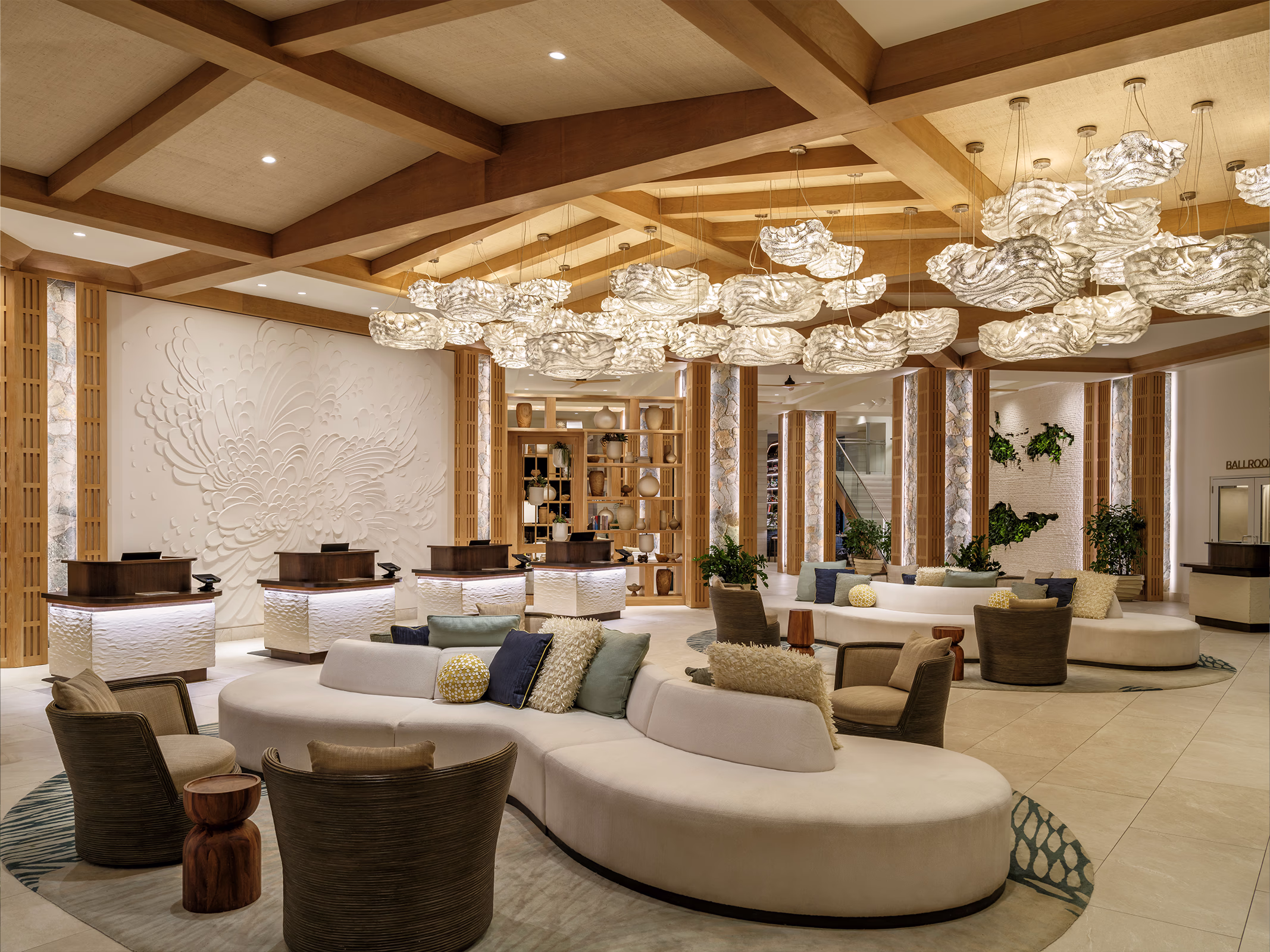 The Westin Frenchman's Reef lobby featuring a floral bas-relief wall sculpture, sculptural cloud pendant lighting, and a wood beam ceiling.
