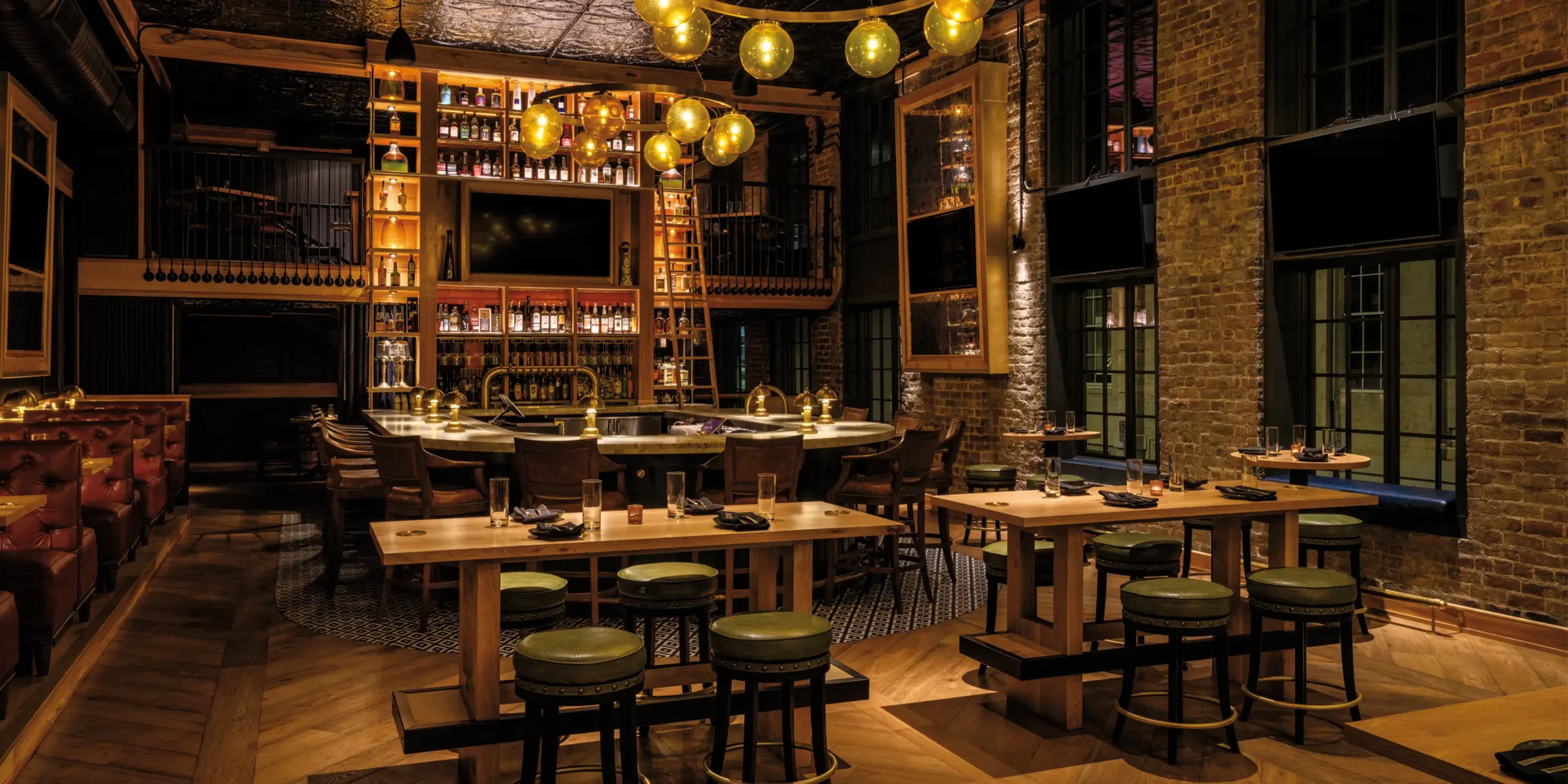Amber glass chandeliers and mosaic tile floor highlighting the central bar area