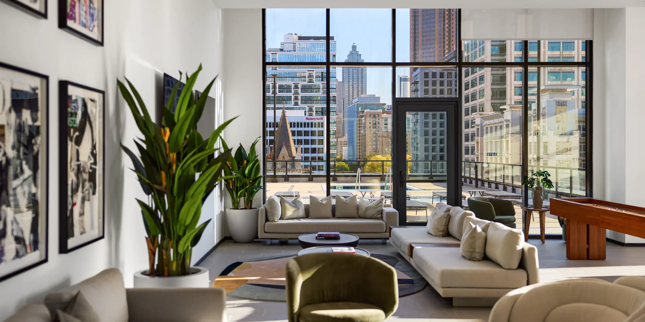 Amenity-level lounge with game tables and view of pool deck at Society Atlanta