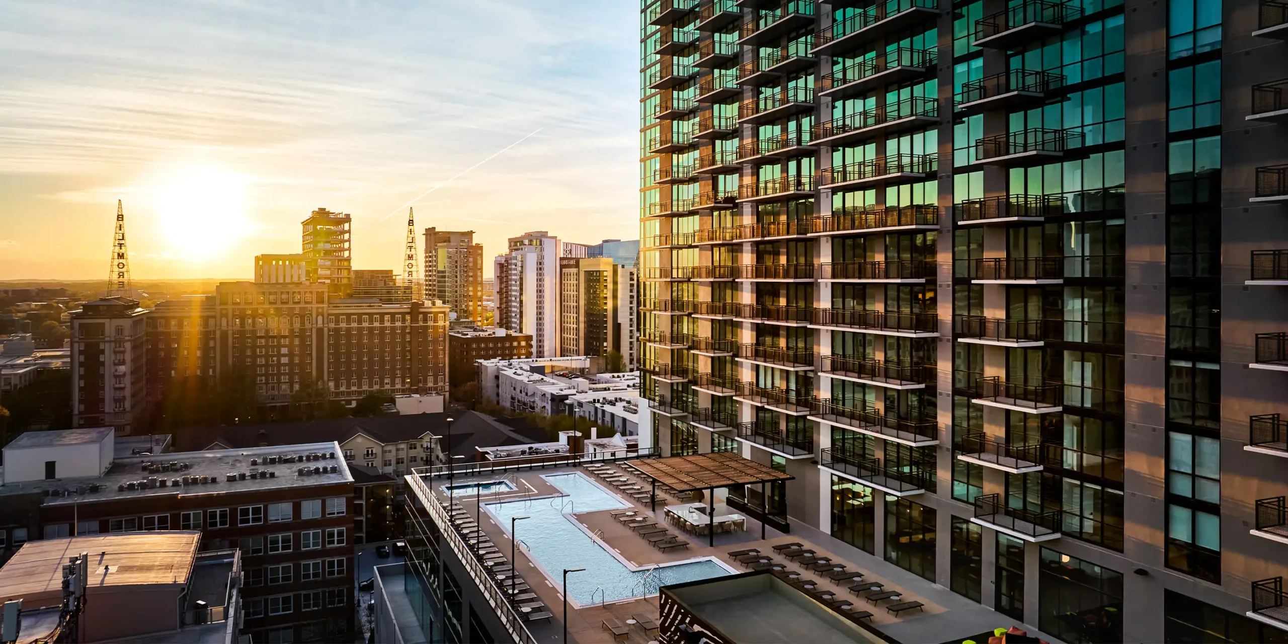 Dusk aerial view of Society Atlanta showing illuminated amenity deck and surrounding Midtown buildings