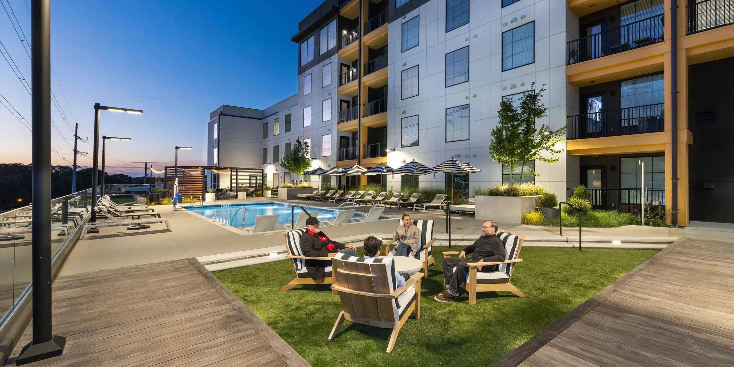 Evening view of The Howell’s illuminated pool deck and amenity courtyard.