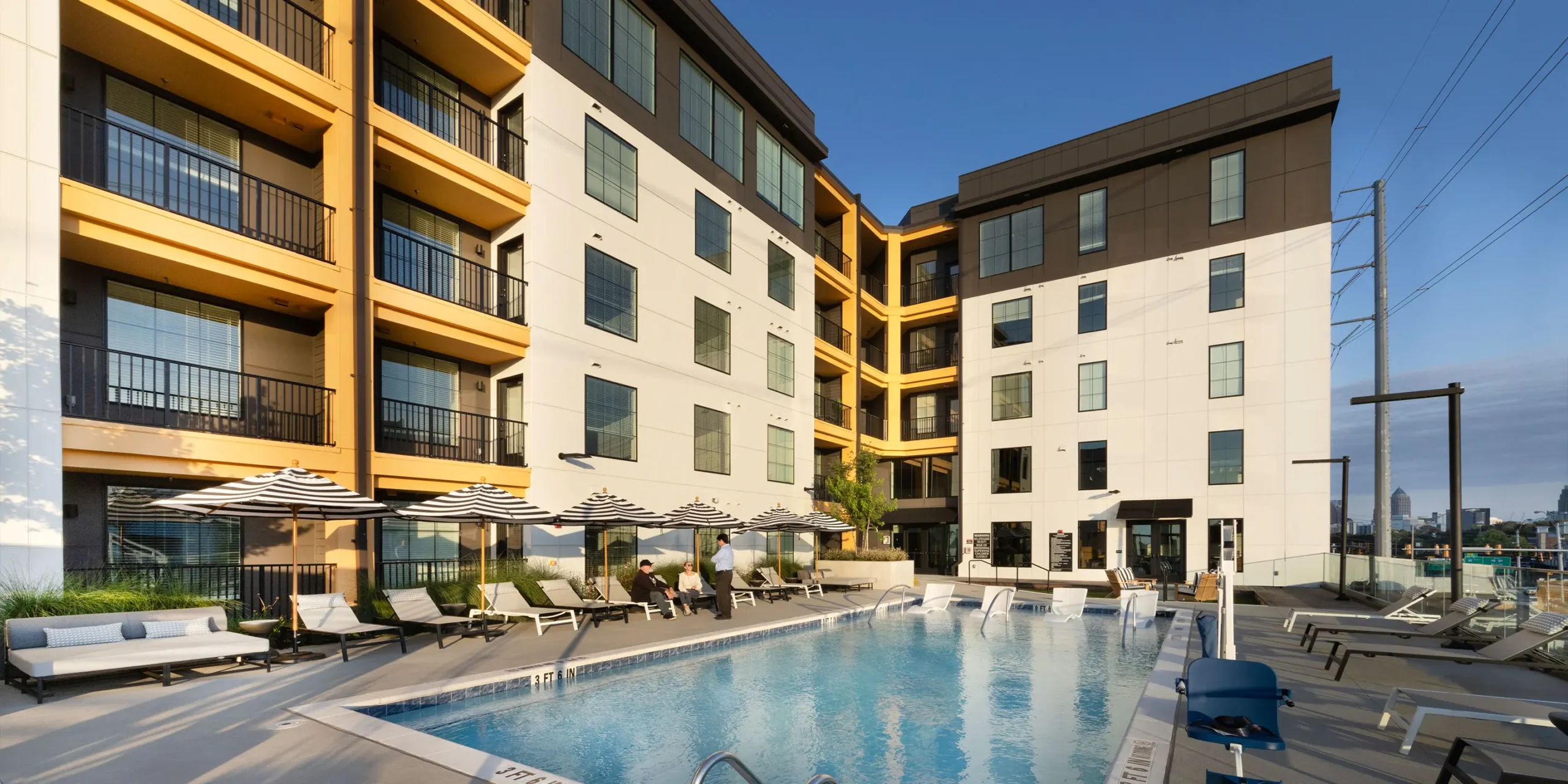 Daytime view of The Howell’s pool and landscaped amenity deck.