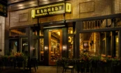 Exterior of The Kennedy gastropub with neon signage, dark blue trim, and glowing interior visible from the street