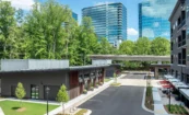 View of retail and residential buildings with MARTA rail line and city skyline in background.