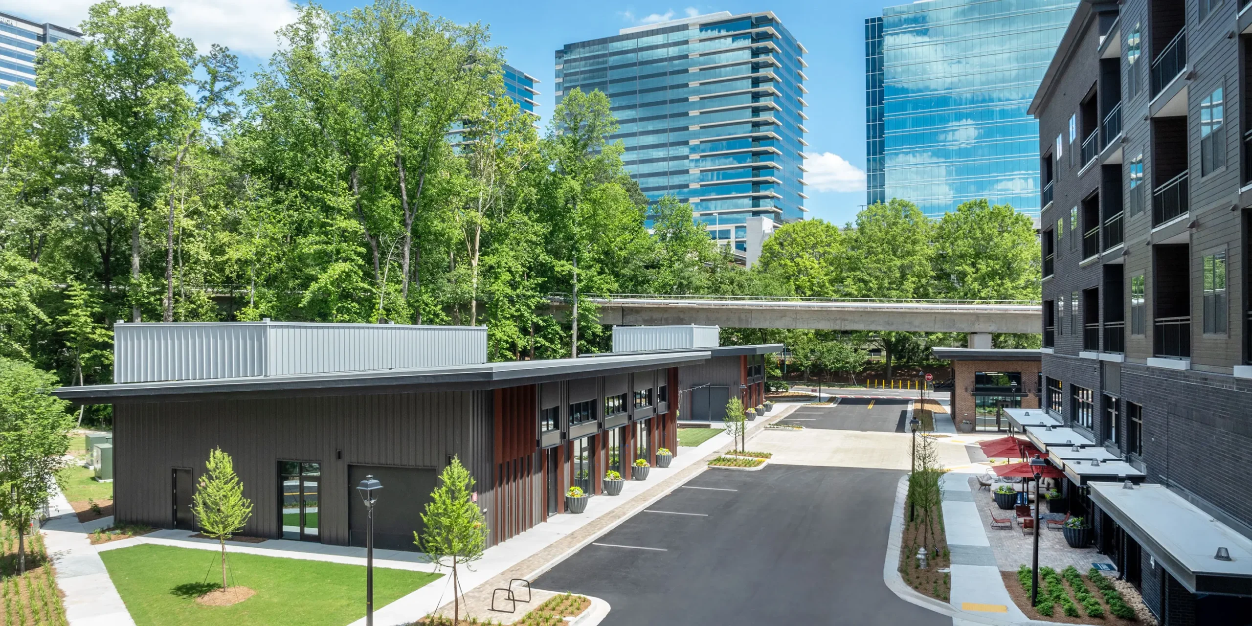 View of retail and residential buildings with MARTA rail line and city skyline in background.