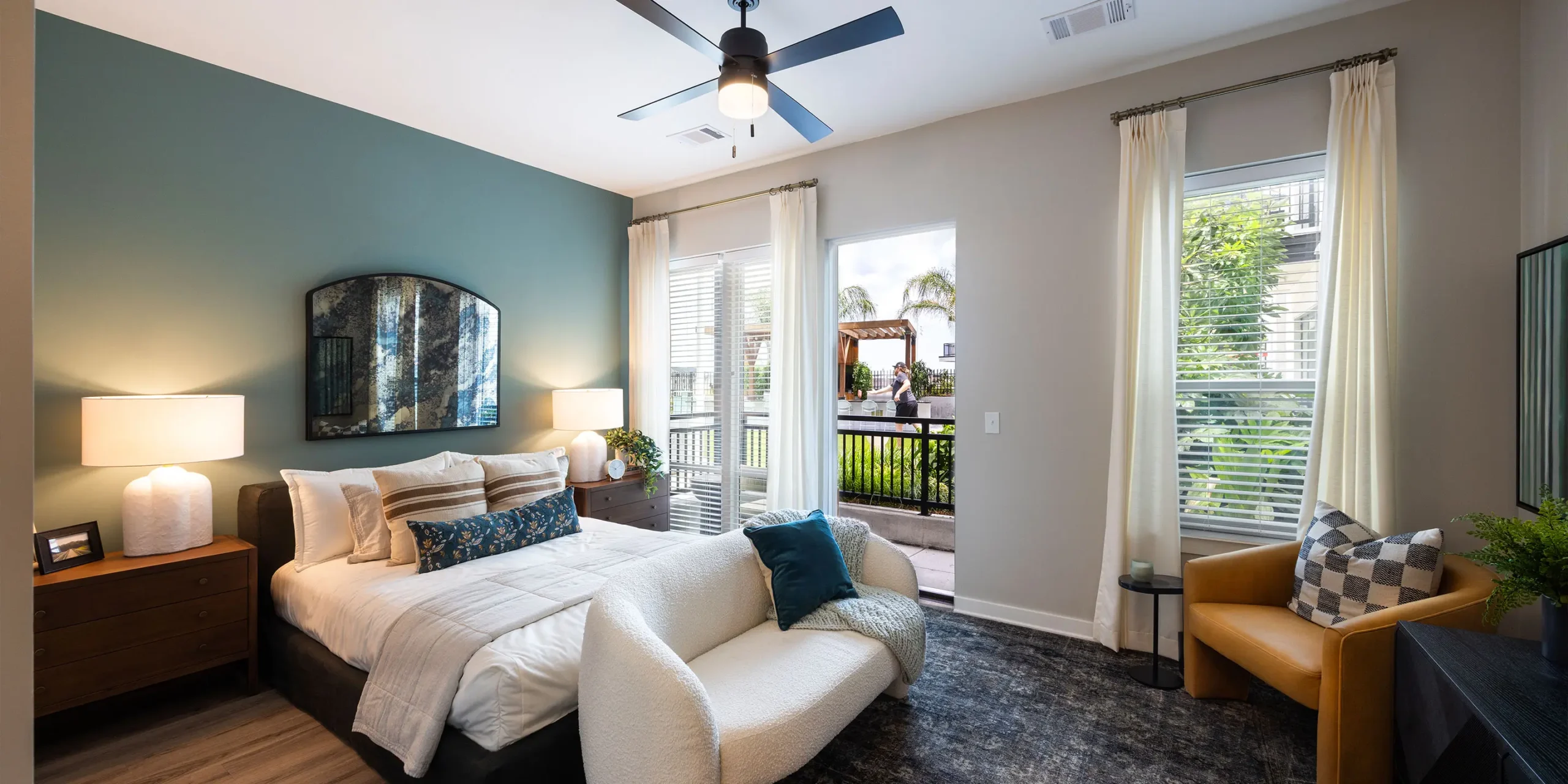 Bedroom interior at Pilot & Park apartments with large windows and city views.