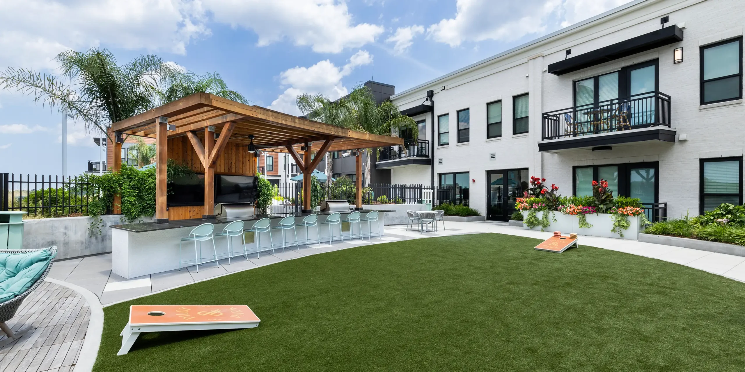 Courtyard at Pilot & Park with timber pavilion, outdoor kitchen, bar seating, and recreation areas.
