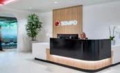 Sompo Atlanta office lobby with modern reception desk and backlit channel letter signage on wood panel