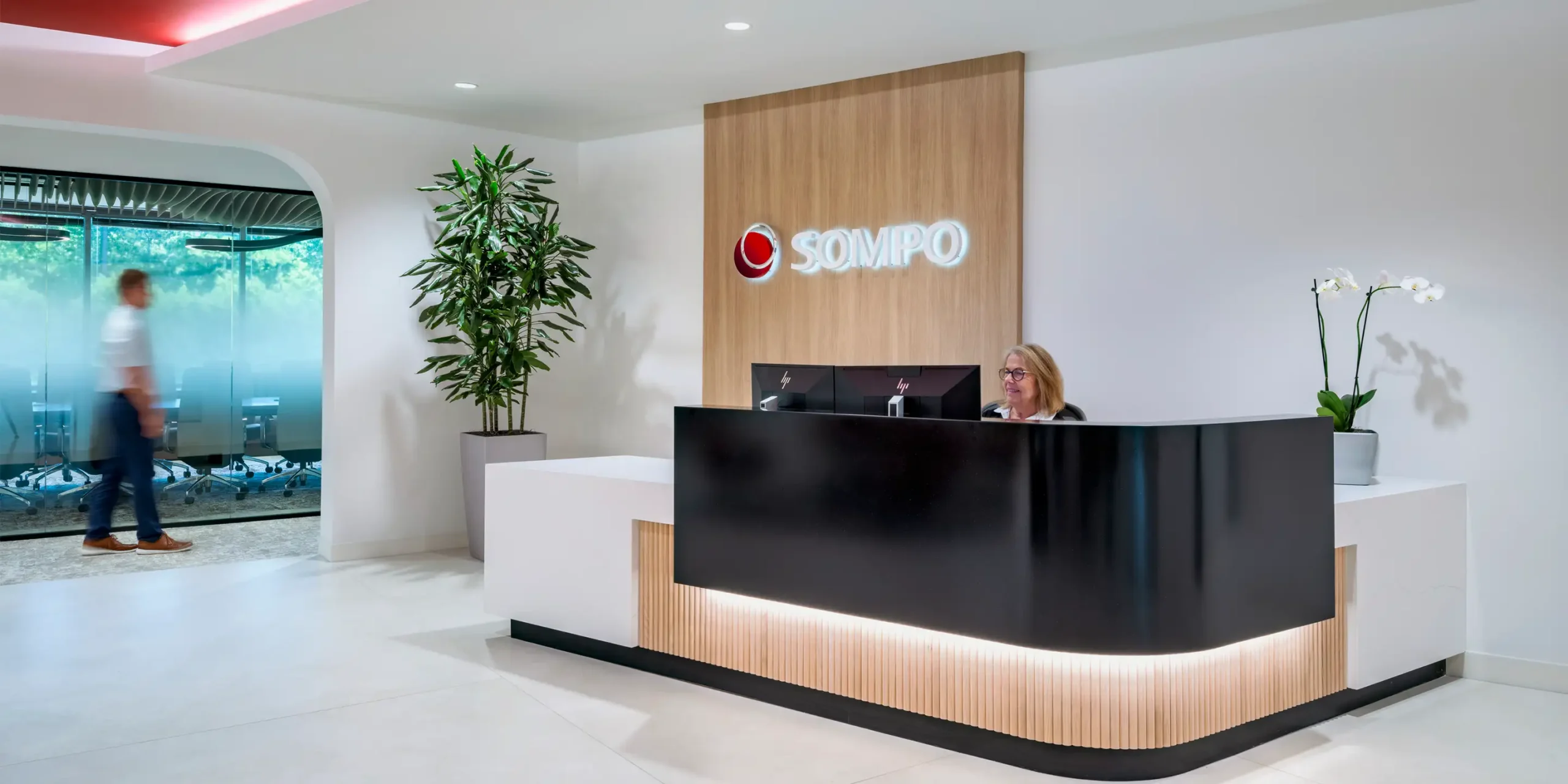 Sompo Atlanta office lobby with modern reception desk and backlit channel letter signage on wood panel
