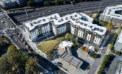 Aerial view of The Howell showing the overall multifamily development next to the highway