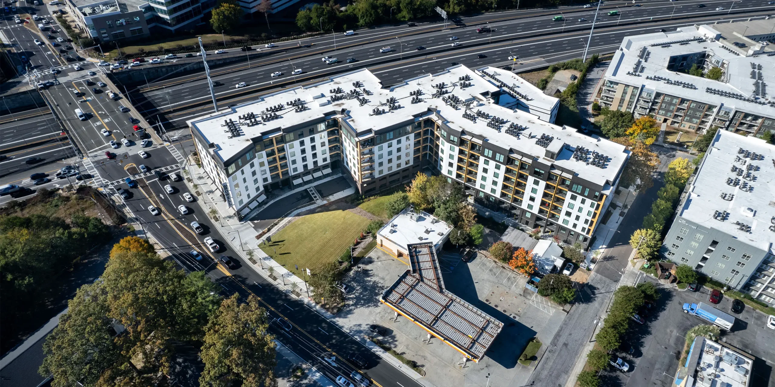 Aerial view of The Howell showing the overall multifamily development next to the highway