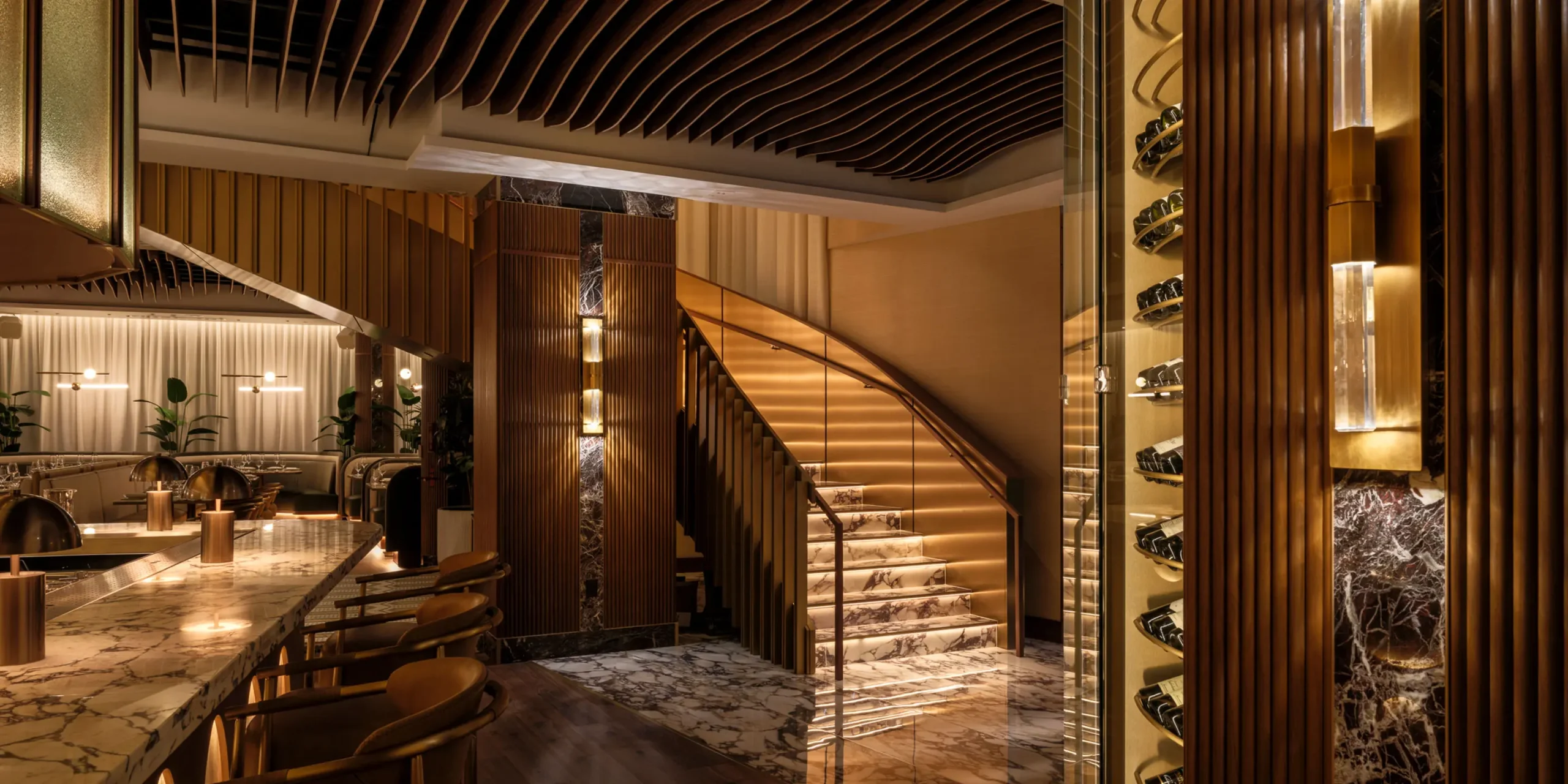 Glowing grand staircase at 1587 Prime connecting dining levels.