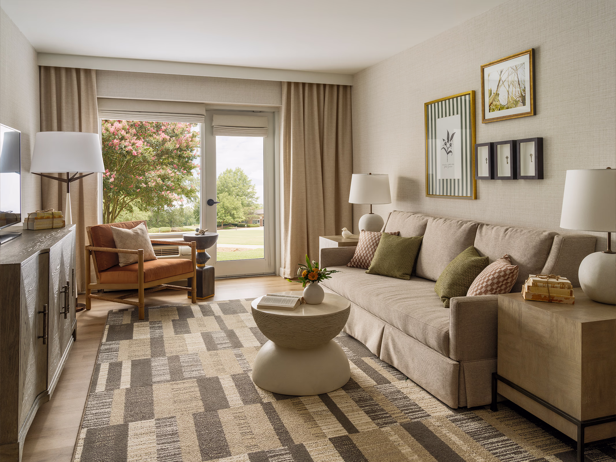 Hospitality suite living area at The James F. Martin Inn featuring a gallery wall with historic room key art and a South Carolina state flower print.