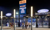 North Gate entrance signage with dimensional layered letters illuminated with blue back-lit lighting at night.