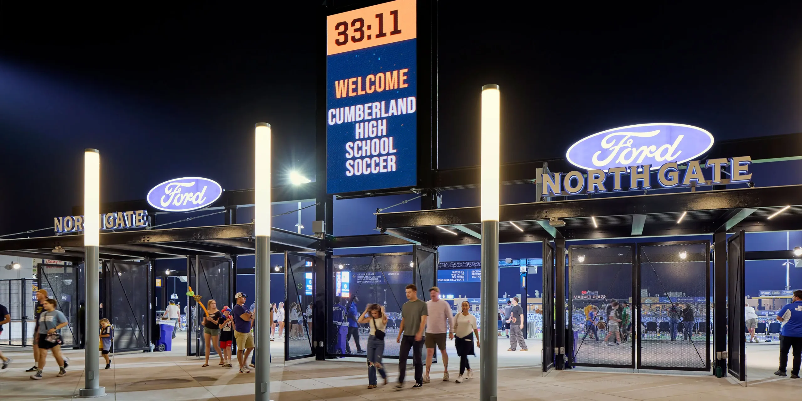 North Gate entrance signage with dimensional layered letters illuminated with blue back-lit lighting at night.
