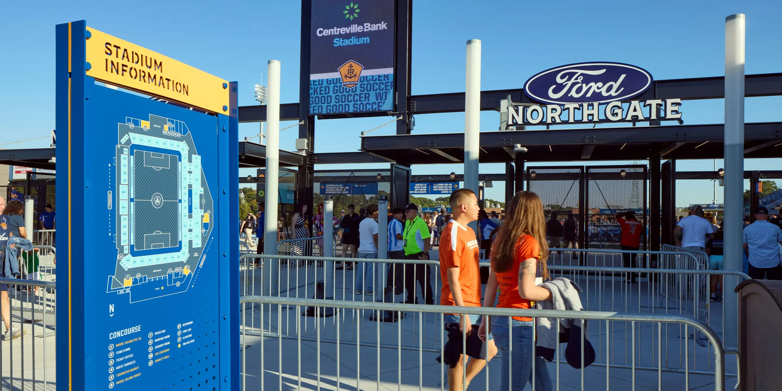 North Gate entrance with illuminated dimensional channel letters and Ford sponsorship signage, with a Stadium Information sign visible in the foreground.