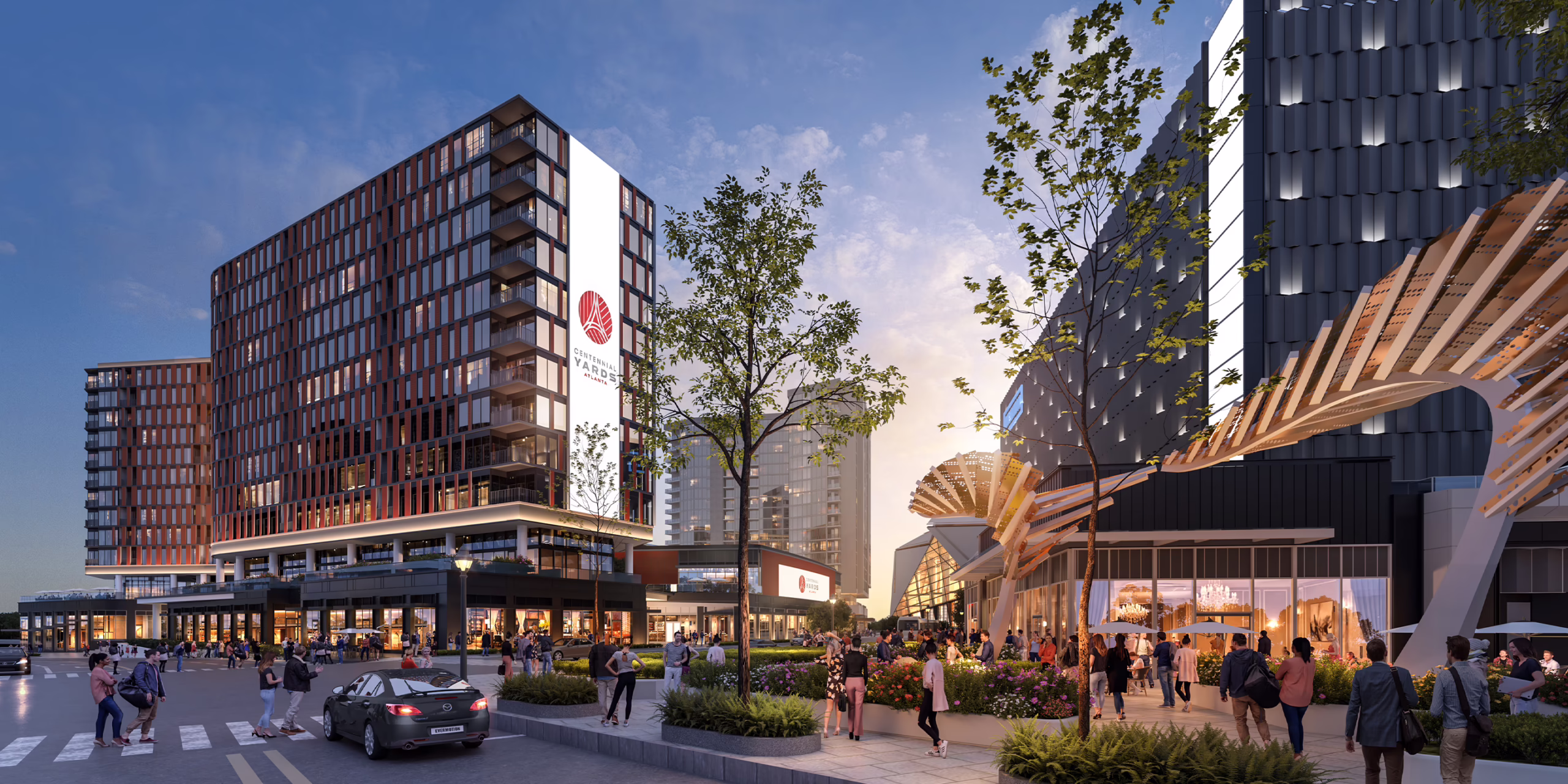 Street-level rendering of the Centennial Yards residential building in Atlanta at dusk, with landscaped plaza, retail storefronts, and pedestrians along Mitchell Street