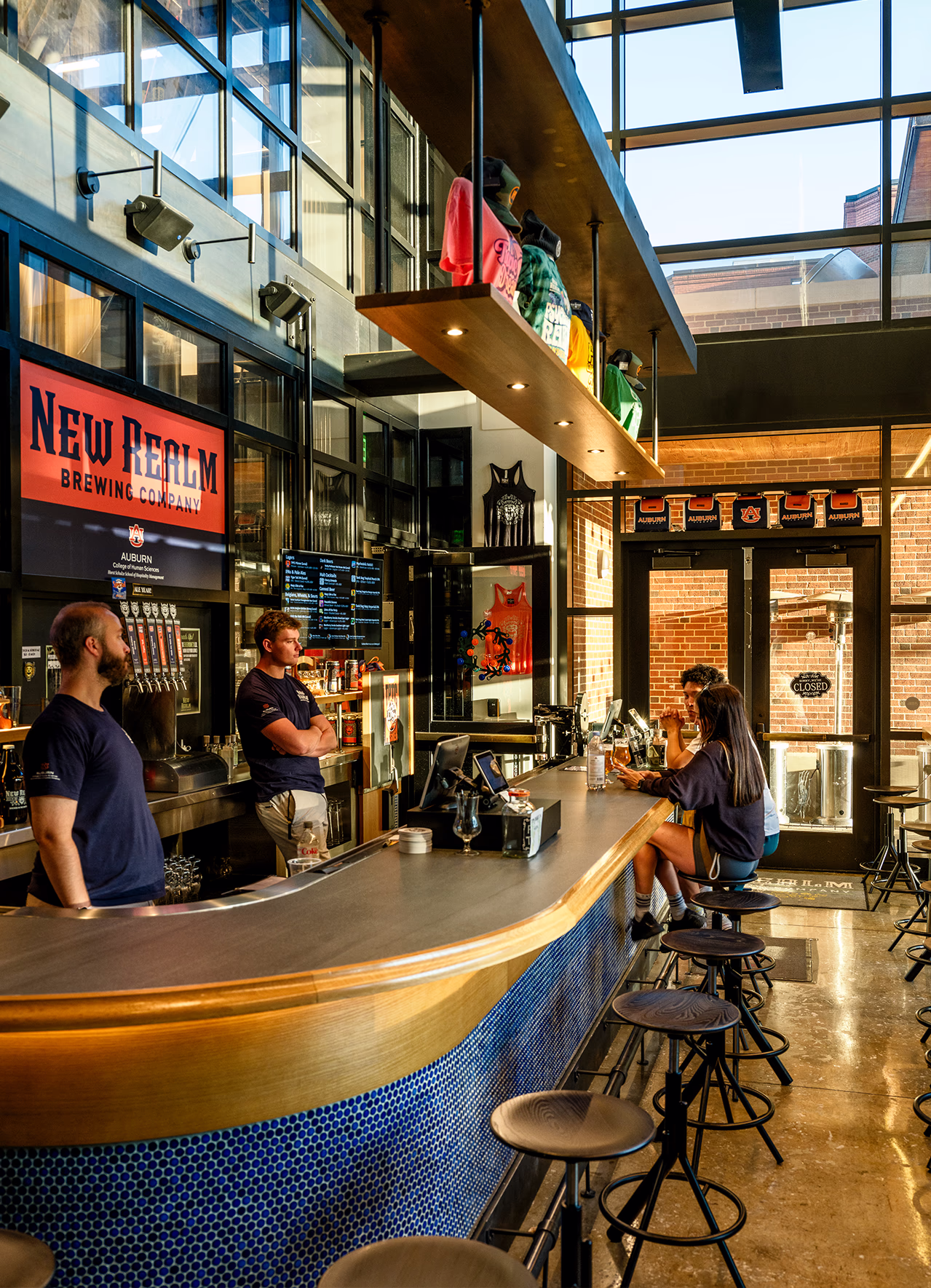 New Realm Brewing Company bar at The Laurel Hotel & Spa's Culinary Science Center at Auburn University, with tap handles, merchandise display, and seating.